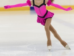 ピンクの衣装で演技をするスケート選手