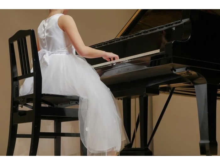 白いドレスでピアノを弾く女の子