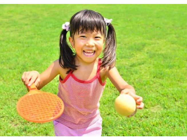 おもちゃのテニスラケットで遊ぶ女の子