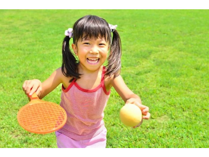 おもちゃのテニスラケットで遊ぶ女の子