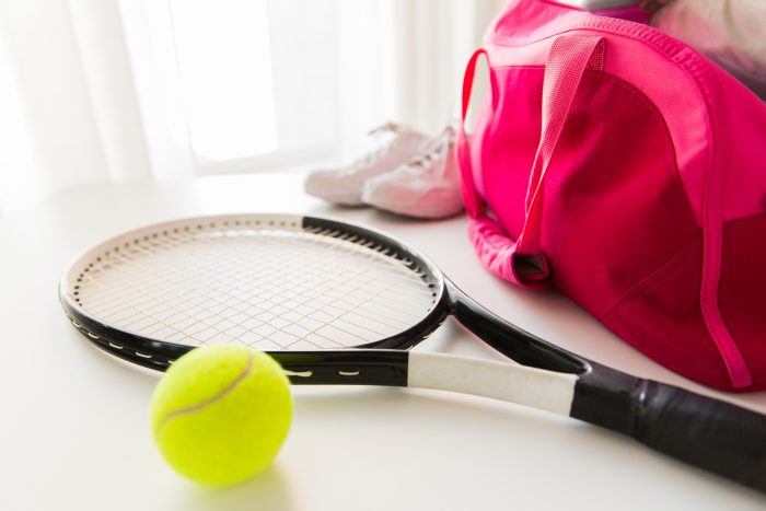 テニスアイテム一式と赤いスポーツバッグ
