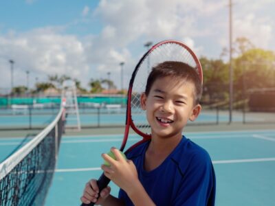 笑顔でテニスラケットを持つ男の子