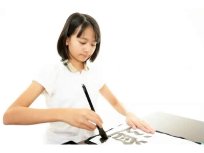 毛筆で書道をする女の子