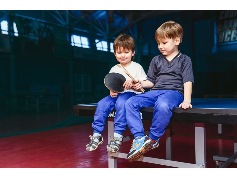 卓球台に座る男の子二人