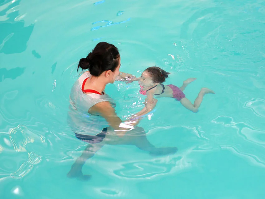 プールで泳ぎの練習をする親子