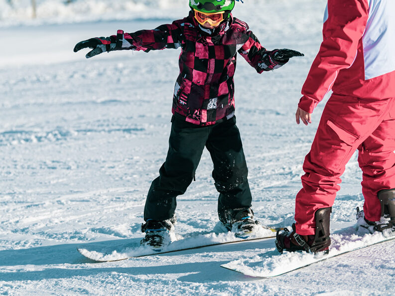 ヘルメットをしてスノーボードをしている子どもの様子