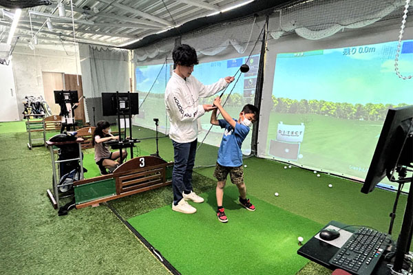 ゴルフ練習をする子供