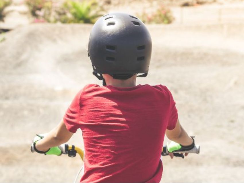 自転車ヘルメットを被る子供