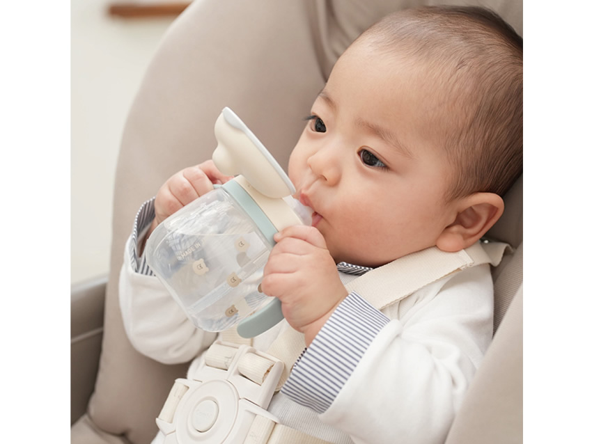 ベビーマグで飲み物を飲む赤ちゃん