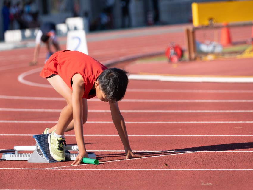 陸上大会でリレーを走る男の子