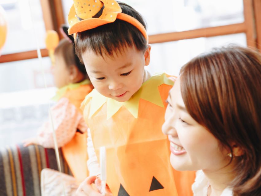 ハロウィンのお菓子を配る女性と子供