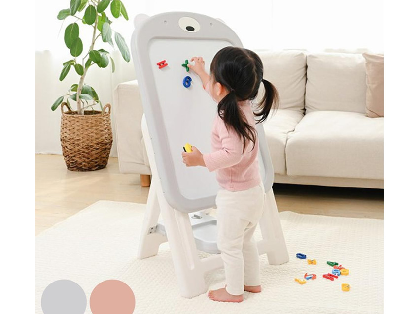 お絵かきボードでマグネット遊びをする子供